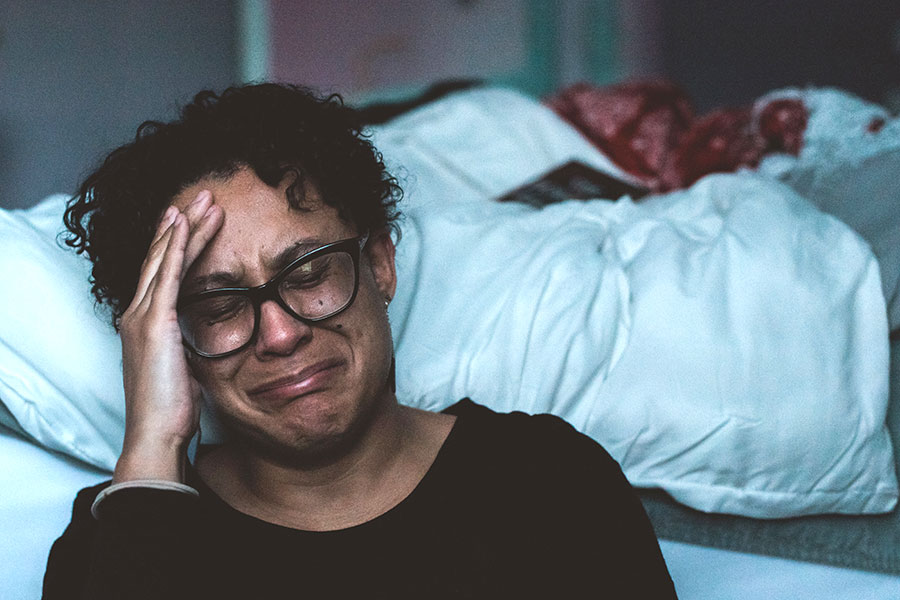 caregiver crying beside bed