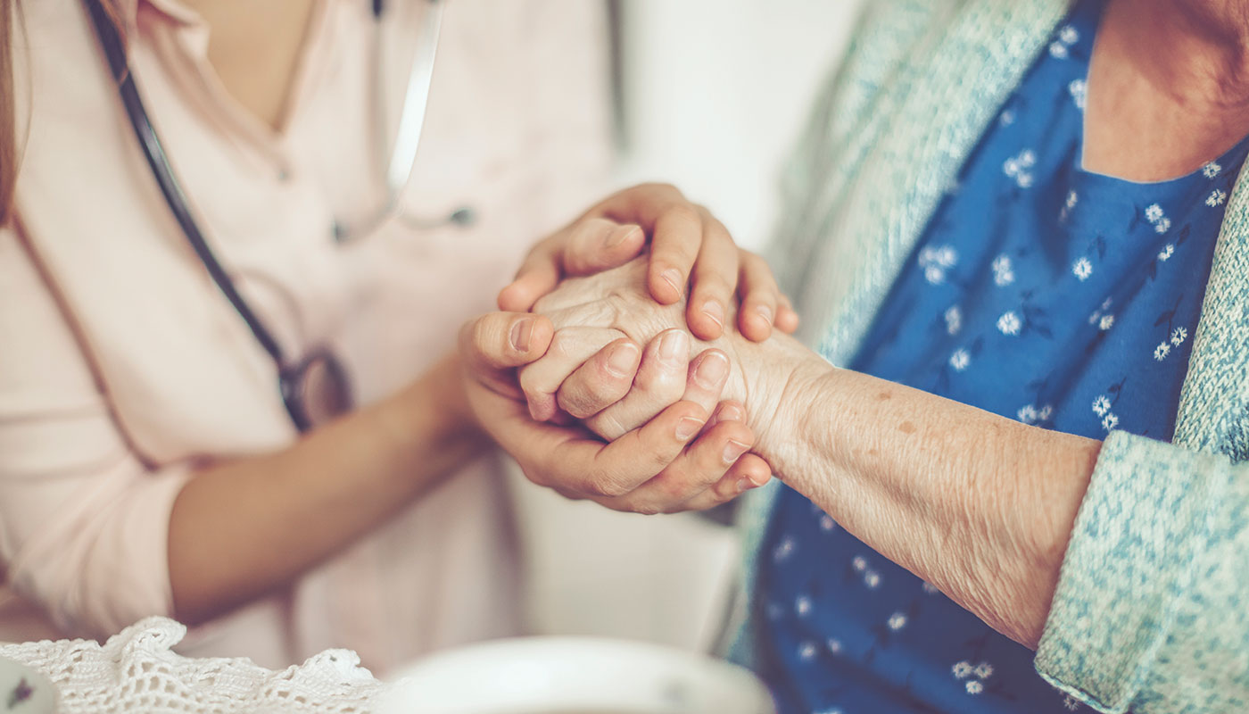 A doctor holding the elderly's hand