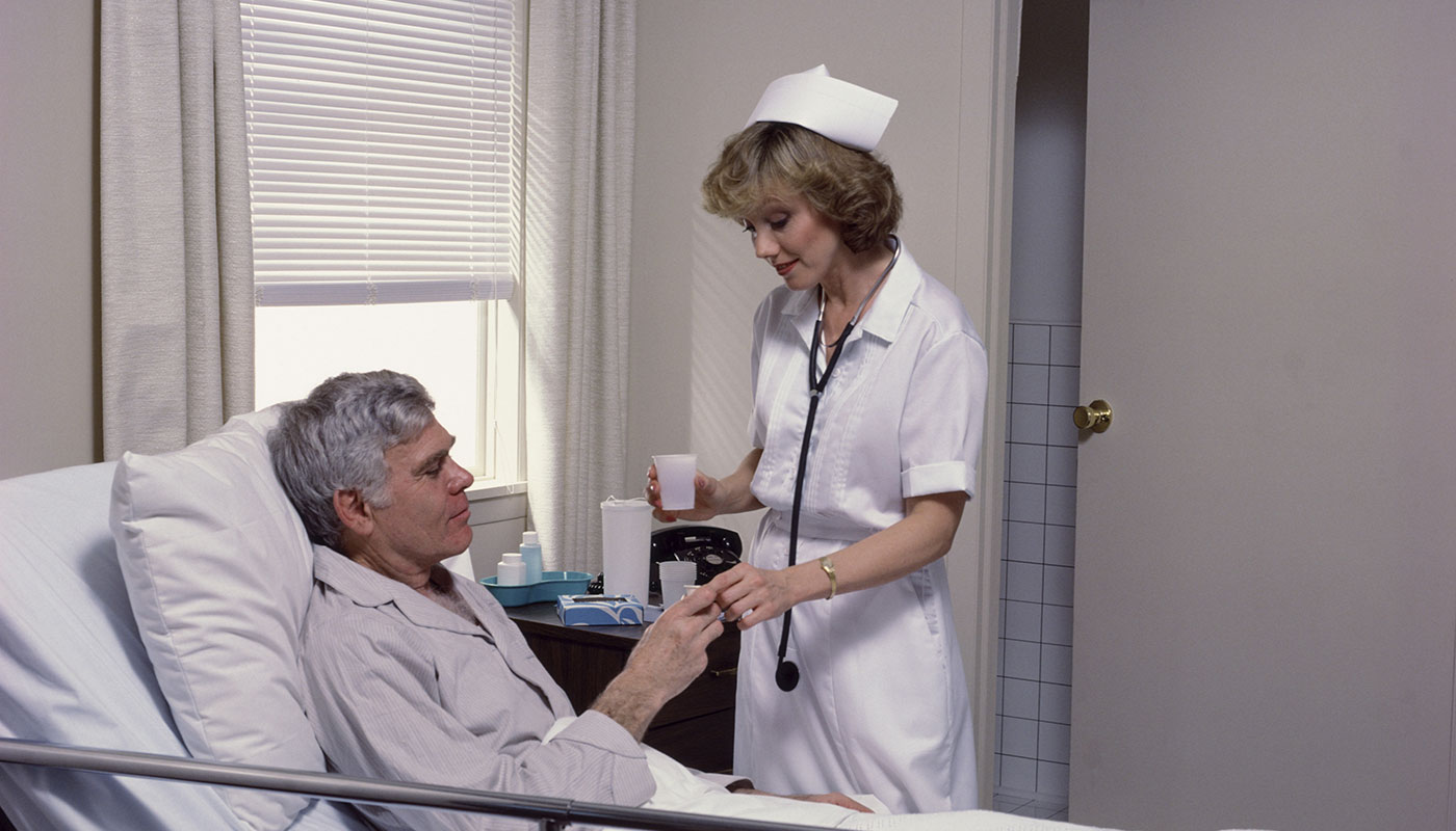 female nurse assisting the elderly patient inside the nursing room