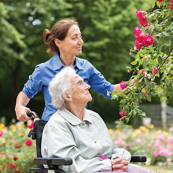 caregiver assisting an elderly in wheelchair