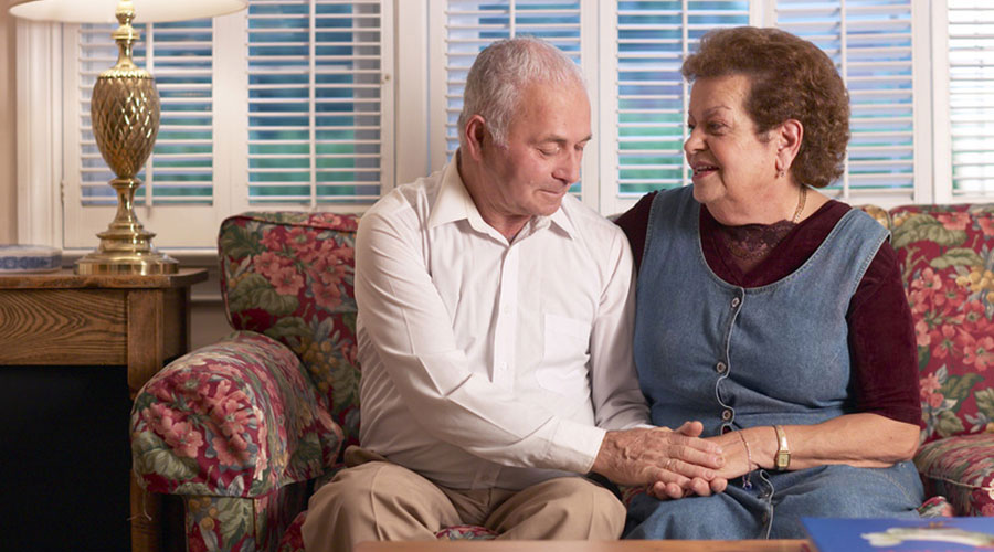 elderly couple holding hands together