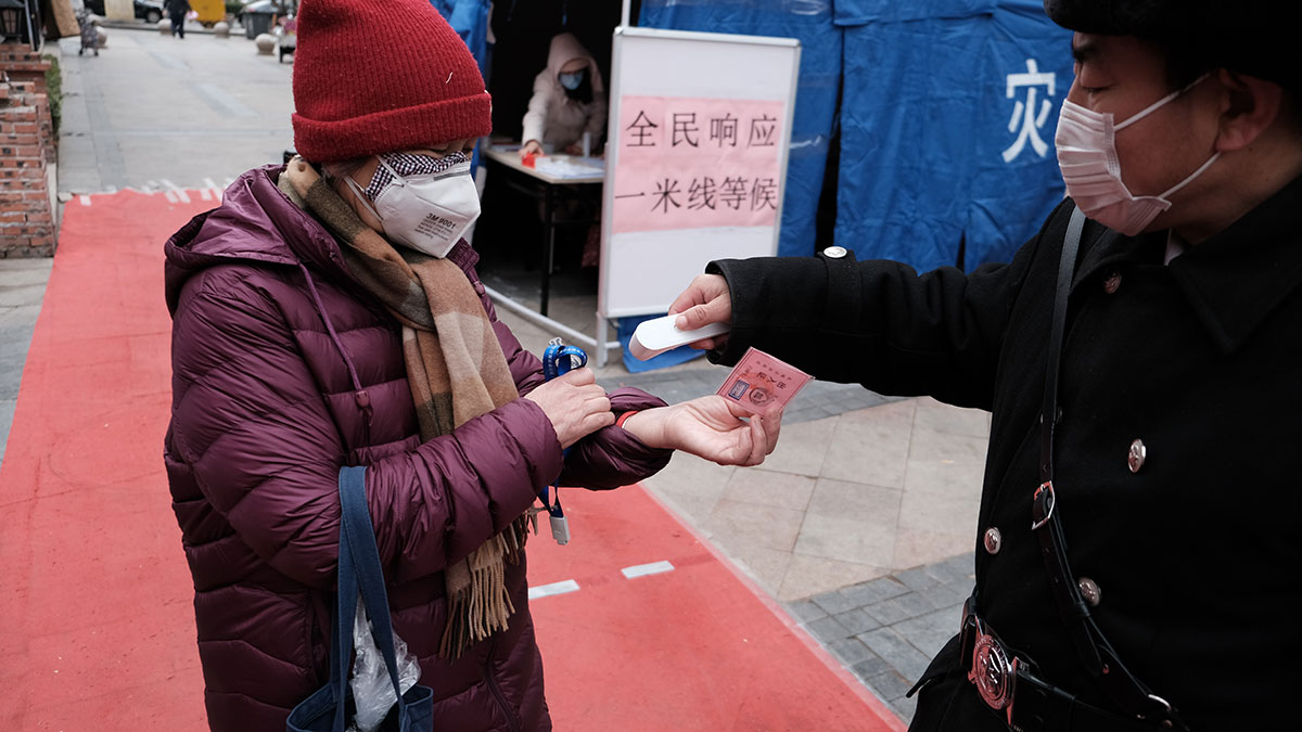 An elderly woman being check for coronavirus symptoms