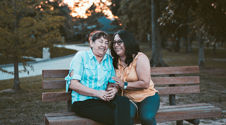 caregiver and an elderly sitting in a park