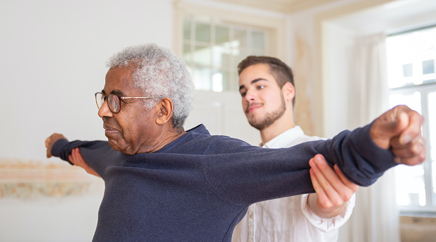 caregiver helping elderly exercise