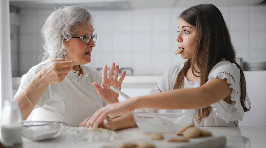caregiver preparing cookies for elderly woman