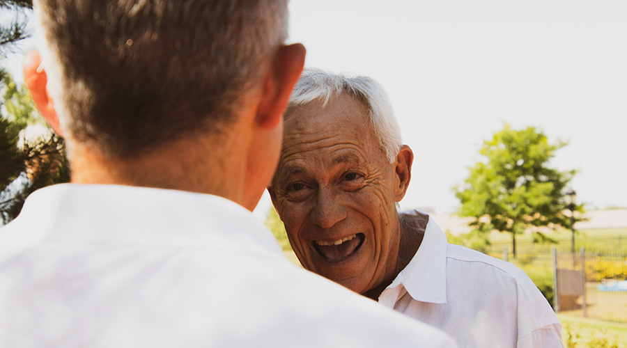 elderly man talking to his male caregiver