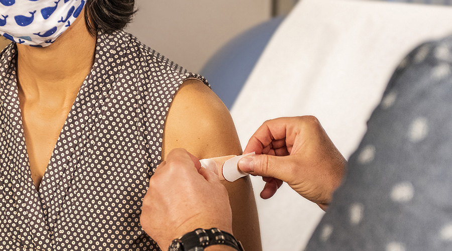 nurse applying protection to the vaccinated arm of a patient