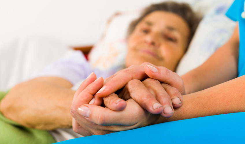 a caregiver comforting a sick elderly
