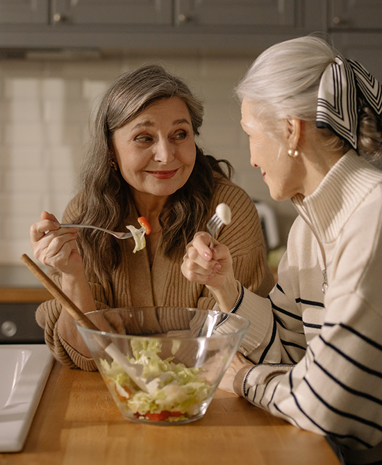2 female seniors eating salad