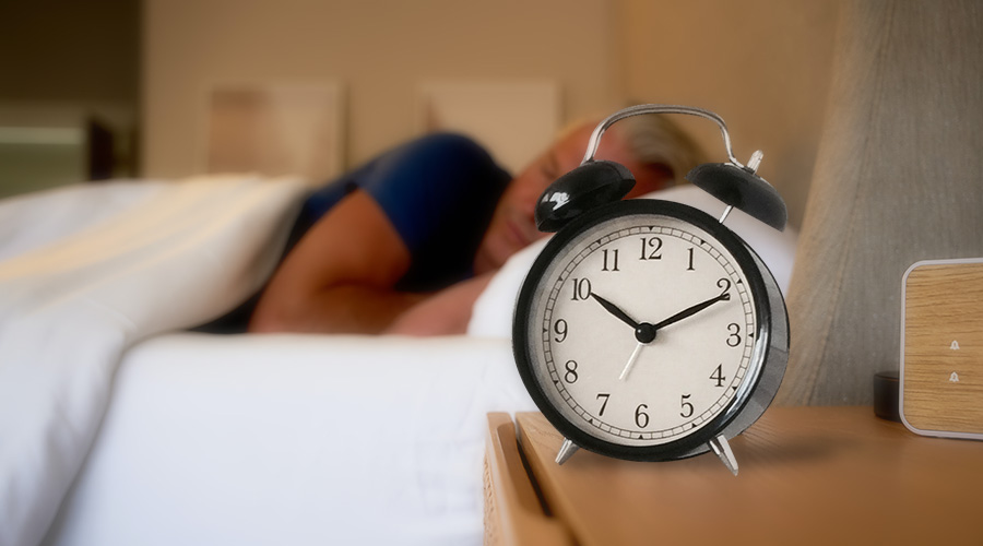 man sleeping with alarm clock