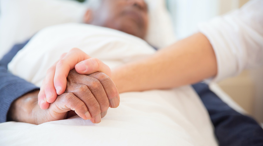 caregiver holding senior's hand