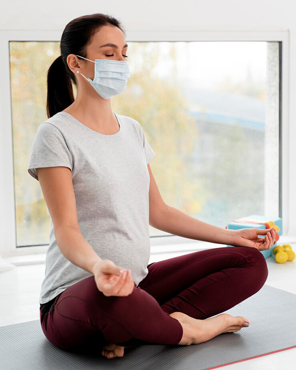 pregnant-woman-with-medical-mask-doing-yoga