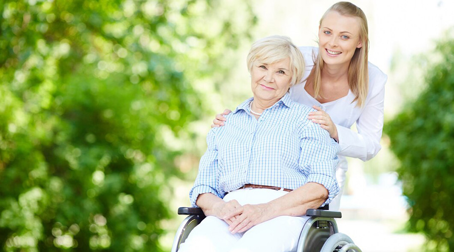 caregiver pushing senior woman wheelchair