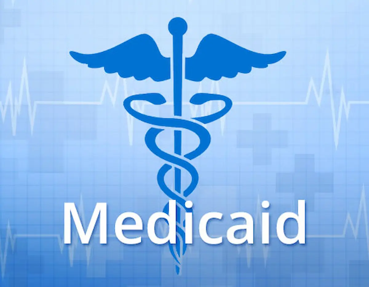A blue caduceus medical symbol above the word Medicaid on a blue background with faint heartbeat lines and medical crosses.
