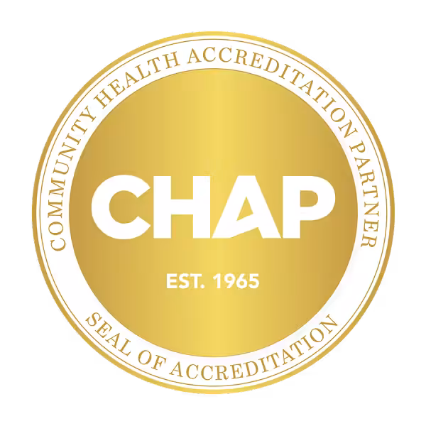 A gold circular seal with the words Community Health Accreditation Partner Seal of Accreditation around the edge and CHAP EST. 1965 in bold white letters in the center, symbolizing excellence in home care.